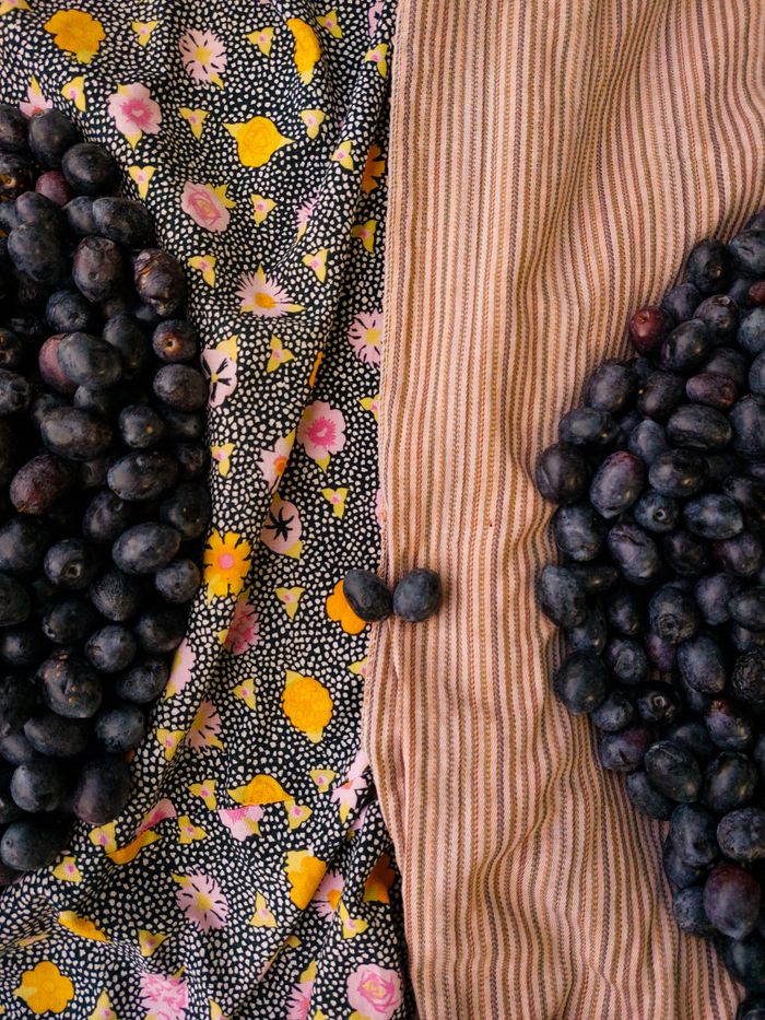 A vertical shot of blueberries on contrasting patterned fabrics, creating a vibrant and healthy fruit display.